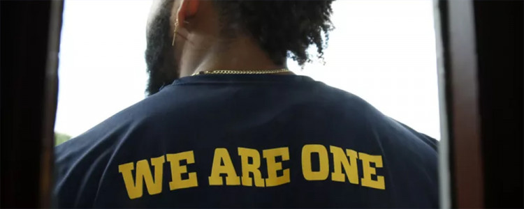 Back of student’s shirt that says “We Are One.”