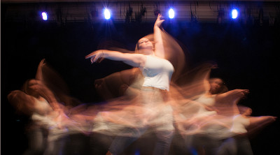 Dancer whose image is blurred by her motion on stage